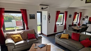 Ein Wohnzimmer mit zwei Sofas, einem Couchtisch und einem Essbereich mit Tisch und Stühlen.