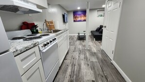 Una cucina piccola con mobili bianchi, un fornello e un lavello.