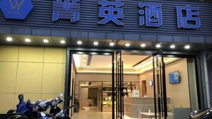 The entrance of a hotel with a glass door and a reception desk inside. - Jingying Hotel (Kunshan)