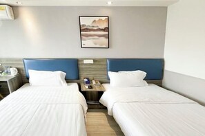 A hotel room with two beds, a small table with a phone and a cup, and a painting on the wall. - Jingying Hotel (Kunshan)