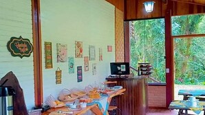 Un'atmosfera rustica con arredi in legno, un lungo tavolo da pranzo, un angolo bar e vista sul verde circostante.