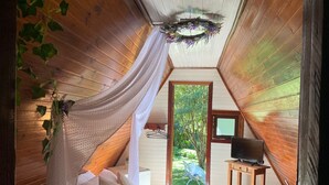Una camera accogliente con un letto, una TV e vista sull'esterno.