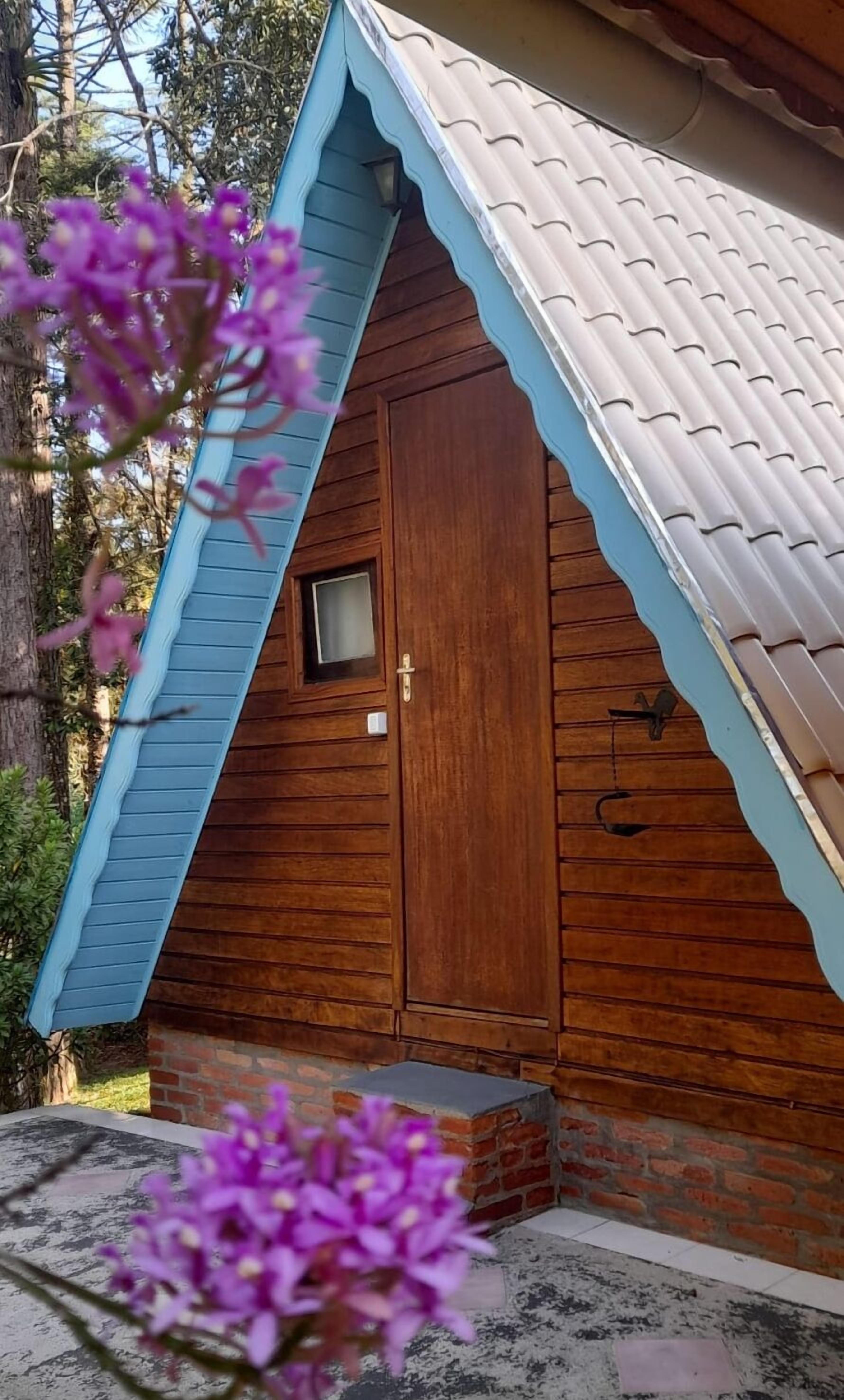 A small wooden cabin with a sloped roof and a single door.