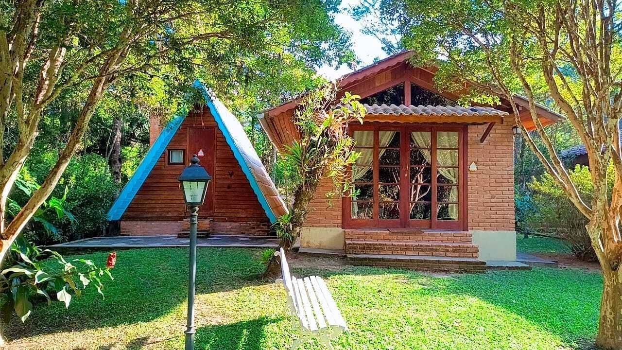A small wooden house with a sloped roof and a brick exterior.