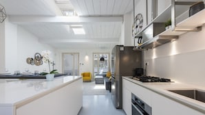 A modern kitchen with a central island, stainless steel appliances, and a bright, open-plan layout. - Apartments Florence - Oltrarno Garden (Firenze)