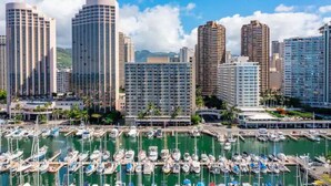 Un port de plaisance où de nombreux bateaux sont amarrés, entouré d’immeubles de grande hauteur.