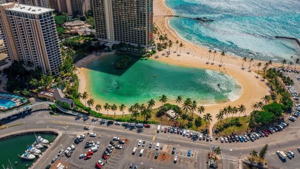 Un paysage urbain côtier avec de hauts immeubles, une plage et un port de plaisance.