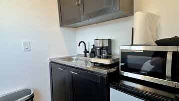 Fridge, microwave, coffee/tea maker, cookware/dishes/utensils