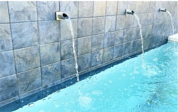 Enjoy a refreshing swim in the pool surrounded by a sleek, tiled wall and a low edge.