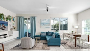 A modern living room with a sectional sofa, a dining table, and a TV. - Roomy Family Home-Sleeps 16 | 109 (Kissimmee)