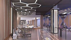 A modern gym with hexagonal ceiling lights, weightlifting equipment, and patterned floor markings. - Microtel by Wyndham Changsha Yuhua (Changsha)