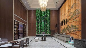 A lobby with a reception desk, seating area, and a decorative wall with vertical gardens. - Microtel by Wyndham Changsha Yuhua (Changsha)