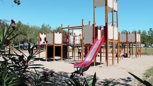 Une aire de jeux avec un toboggan et des structures d’escalade.