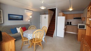 A compact kitchen with wooden cabinets, a microwave, and a refrigerator.