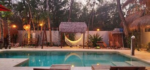 Una piscina al aire libre, camas de piscina gratis, sombrillas