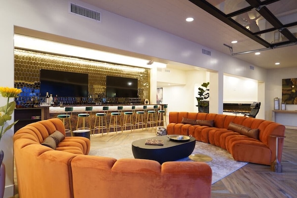 Stylish bar and lounge area with TV's, projector, and custom chandelier