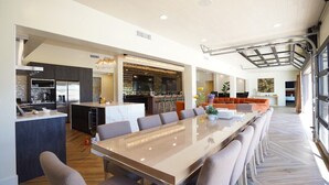 Una cocina amplia con electrodomésticos modernos, un comedor con una mesa grande y una barra.