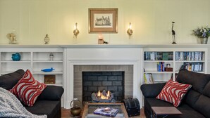 A living room with two sofas, a fireplace, a bookshelf, and decorative items. - Home adjacent to Country Club, near Hospitals, Park, College and shopping. (Ada)