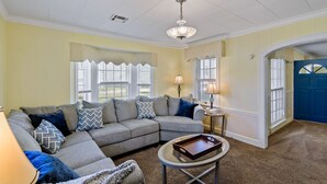 A living room with a sectional sofa, a round coffee table, and a chandelier. - Home adjacent to Country Club, near Hospitals, Park, College and shopping. (Ada)