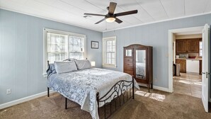 A bedroom with a bed, a dresser, and a ceiling fan. - Home adjacent to Country Club, near Hospitals, Park, College and shopping. (Ada)