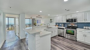 A modern kitchen with white cabinets, a stainless steel oven, and a microwave. - Oceanfront Luxury Condo - 3BD with Gorgeous Views - Oceanfront Pool (North Myrtle Beach)