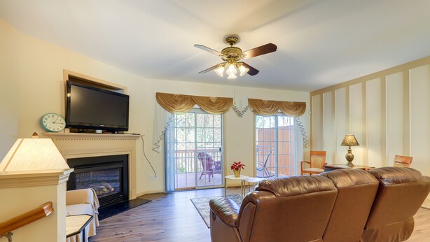 A living room with a fireplace, leather sofa, television, and a ceiling fan. - Decatur Vacation Rental ~ 5 Mi to Downtown Decatur (Decatur)