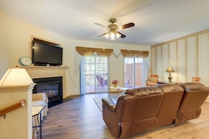 A living room with a fireplace, leather sofa, television, and a ceiling fan. - Decatur Vacation Rental ~ 5 Mi to Downtown Decatur (Decatur)