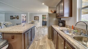 A modern kitchen with granite countertops, stainless steel appliances, and wooden cabinets. - West Mineral Vacation Rental Home w/ Fire Pit! (West Mineral)