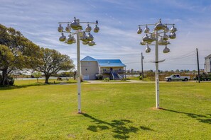 A grassy area with two white lamp posts and a blue-roofed building in the background. - Sneads Ferry Vacation Rental Studio w/ Water Views (Sneads Ferry)