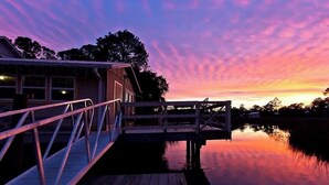 A wooden dock extending into calm water with a sunset sky. - Creekside Paradise • Sunsets, Pool, Spa, Dock, Kayaks (Tybee Island)