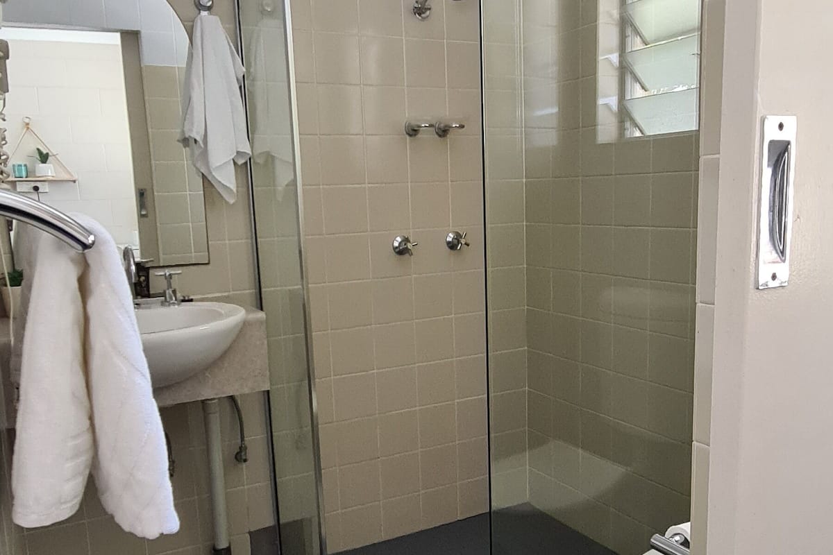 Une salle de bain moderne avec une douche à parois de verre, un lavabo blanc et des toilettes.