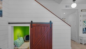 Ein Zimmer mit einer Holztür, die sich verschieben lässt, einer grünen Wand und einer weißen Decke.