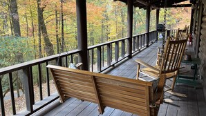 A wooden deck with benches overlooking a forested area.