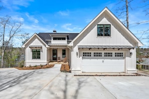 A two-story house with a garage, a front porch, and a driveway.