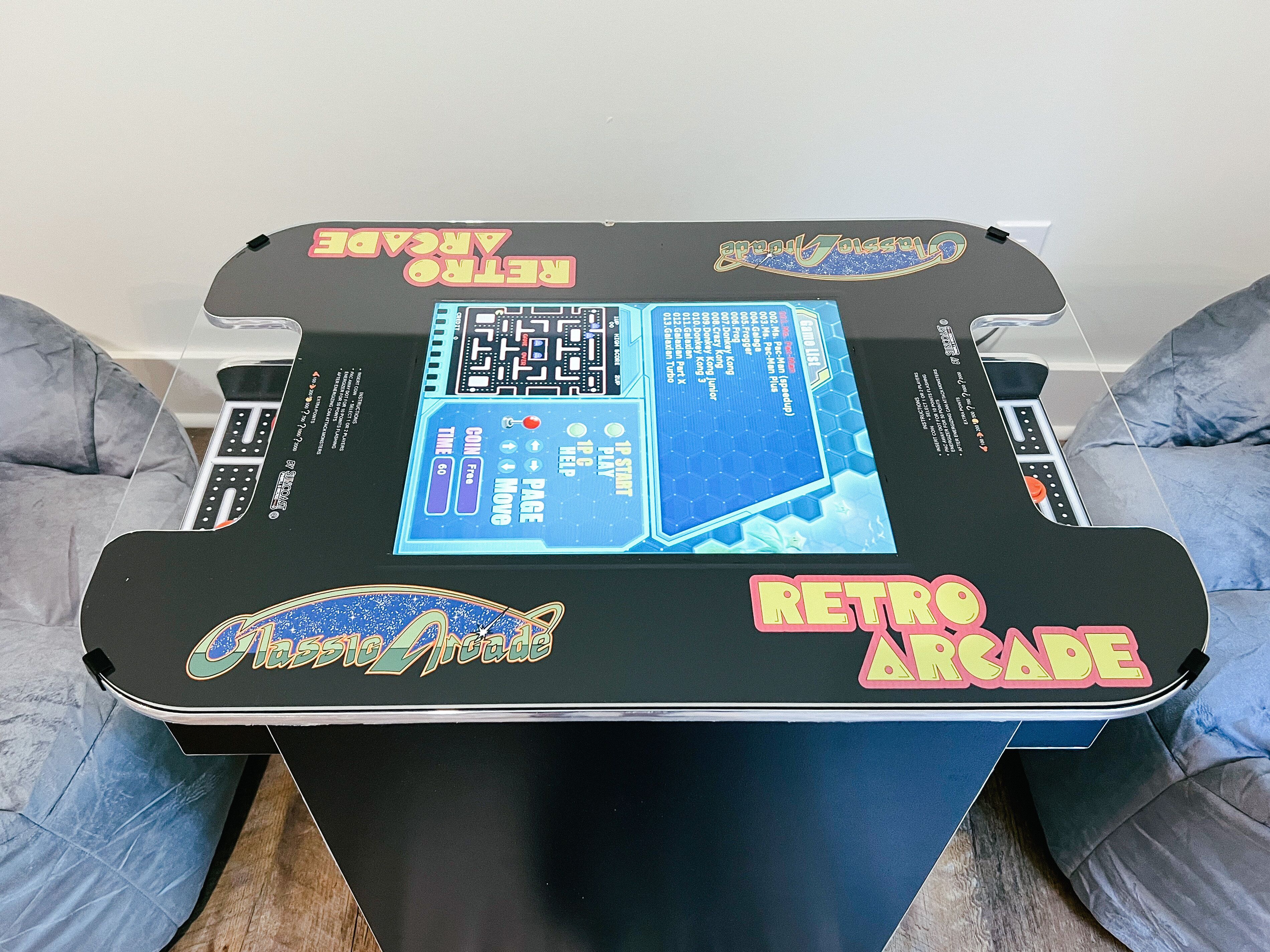 Ein Retro-Spiellautomobil mit digitalem Bildschirm, Münzeinslot und Spieleauswahlknöpfen.