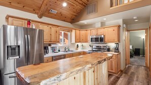 A modern kitchen with wooden cabinets, stainless steel appliances, and a large island.