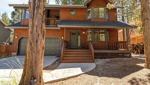 A two-story wooden house with a front porch, a garage, and a visible address number.