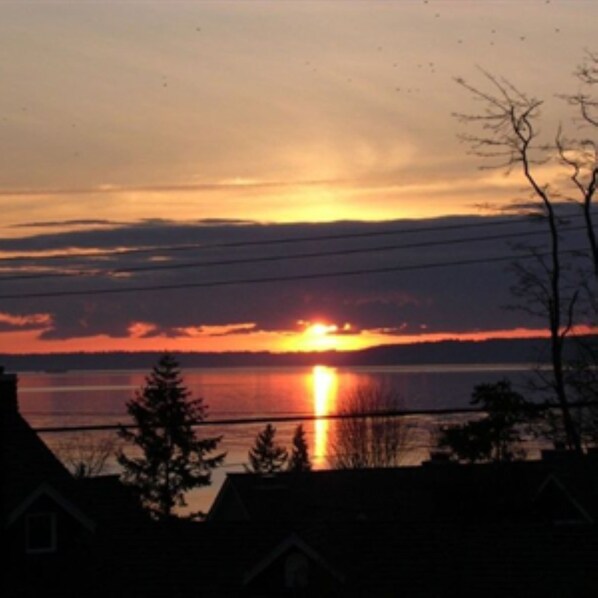 A sunset over a body of water with silhouettes of houses and trees. - Redondo Beach Bungalow (Des Moines)