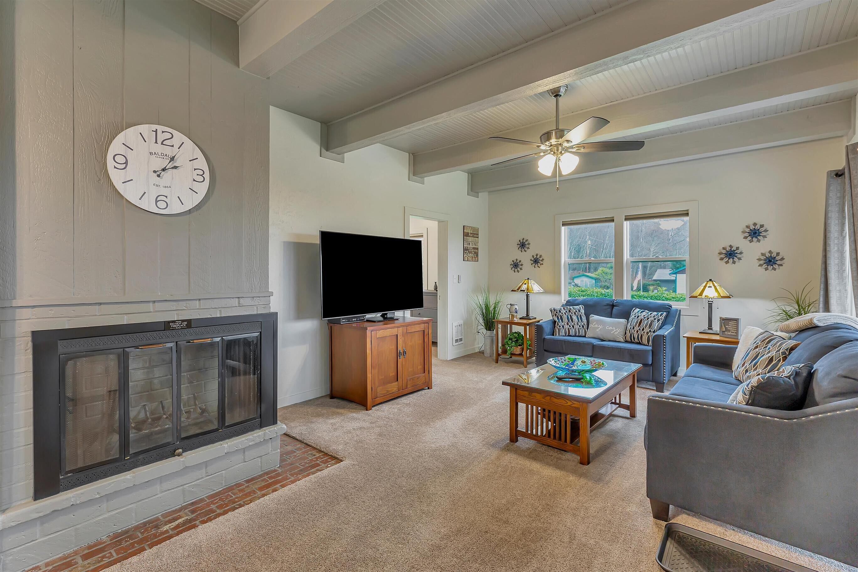 A living room with a fireplace, a television, a sofa, and a coffee table.