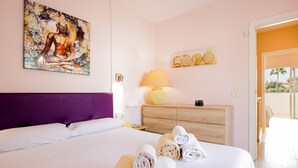 Hotelkamer met een bed, hoofdeinde, schilderij, lamp, een houten dressoir en uitzicht op de omgeving.