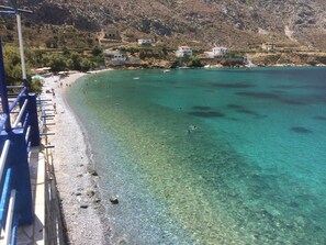 A coastal beach with clear turquoise waters, rocky terrain, and scattered buildings. - Beachfront Apartment - Sleeps 4 & Free Parking (Arginonta)