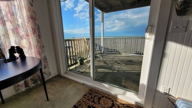 Une chambre avec vue sur une terrasse en bois et un balcon.