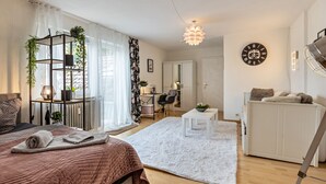 Un dormitorio moderno con cama, alfombra blanca, escritorio, silla, armario y un reloj de pared.