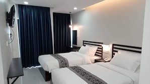 A hotel room with two beds, a desk, a TV, and a phone on the nightstand. - Hotel Chom Chao City (Phnom Penh)