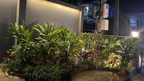 A well-lit outdoor area with various potted plants and a modern building structure in the background. - Hotel Chom Chao City (Phnom Penh)