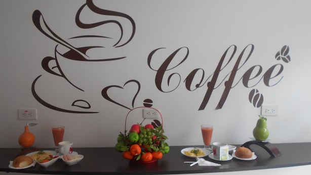 A wall with a coffee-themed decor, including a coffee cup and heart design, and a counter with breakfast items.