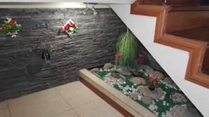 A staircase with a wooden handrail and a stone wall with decorative flower arrangements.
