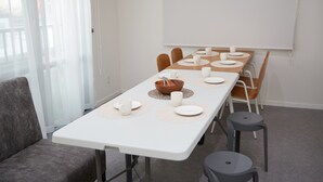 Comedor con una mesa blanca dispuesta para seis personas, con platos, tazones y tazas.