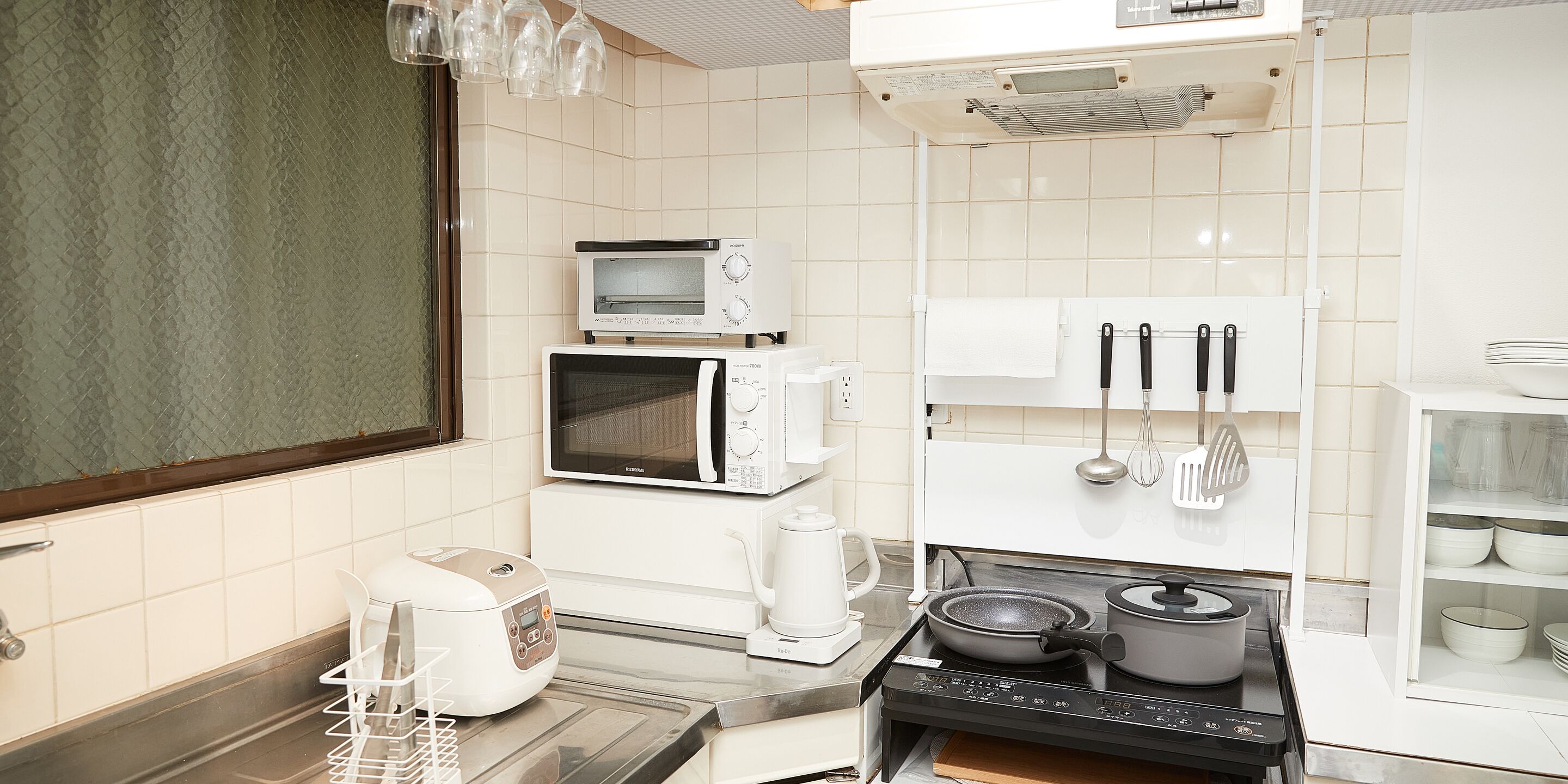 A modern kitchen with a stove, microwave, and coffee maker.
