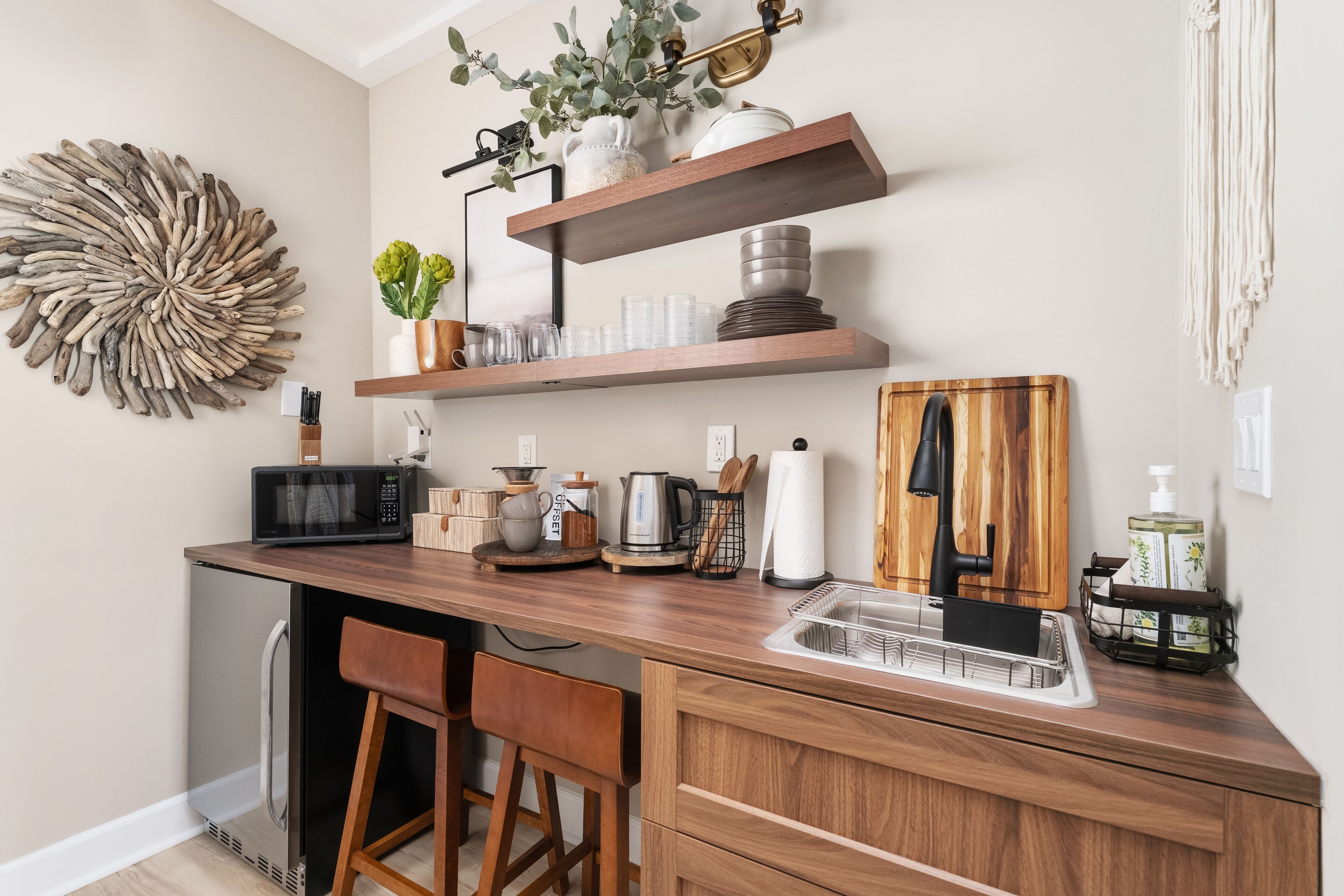 A kitchen with wooden countertops, a built-in microwave, a coffee maker, and a sink.